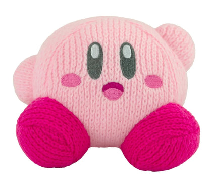 A pink knitted plush toy shaped like Kirby, featuring a light pink body, darker pink yarn feet, and embroidered facial features on a plain white background.