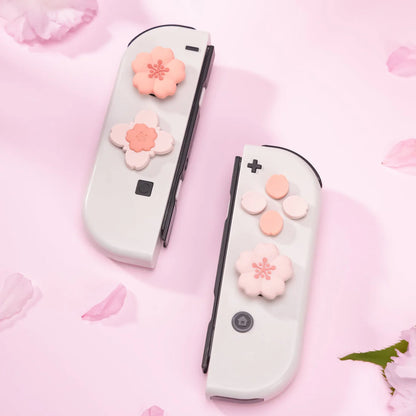 Two gaming controllers with pink flower designs on a pink background